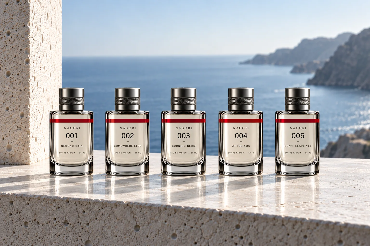 The five 20 ml bottles, 001 to 005, in a row on a sunlit stone ledge above the sea